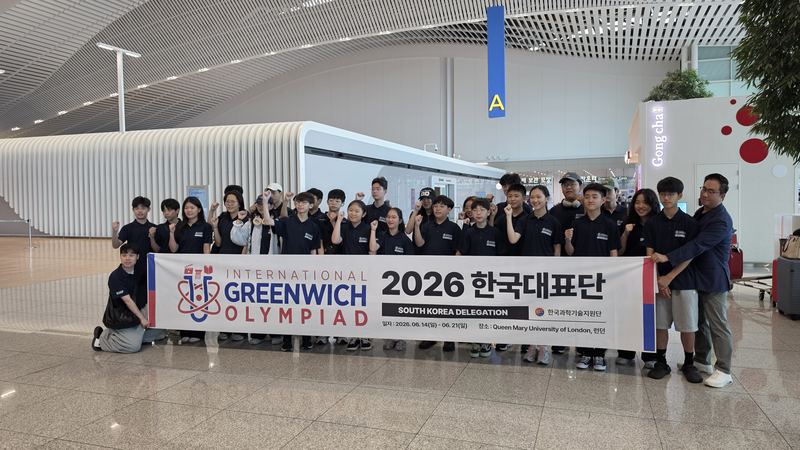 The South Korea delegation holding an International Greenwich Olympiad banner at Incheon Airport