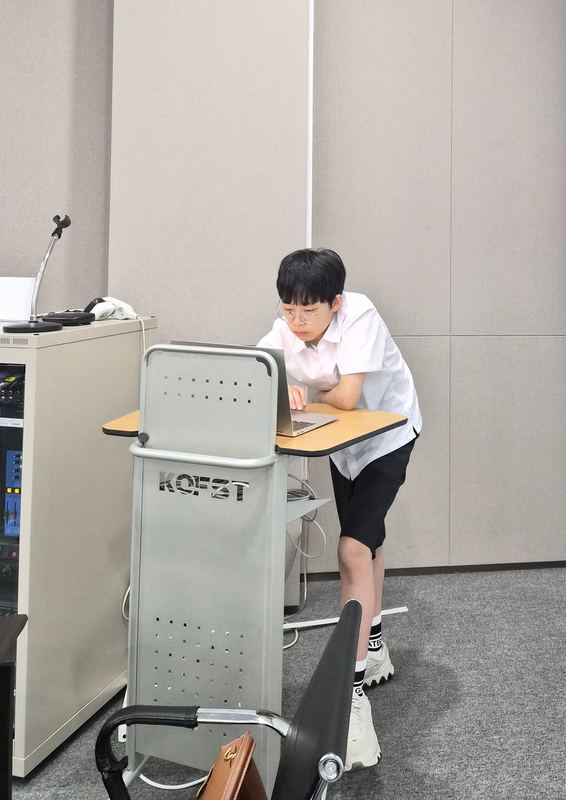 Mark preparing his presentation at a lectern during the national round in Seoul