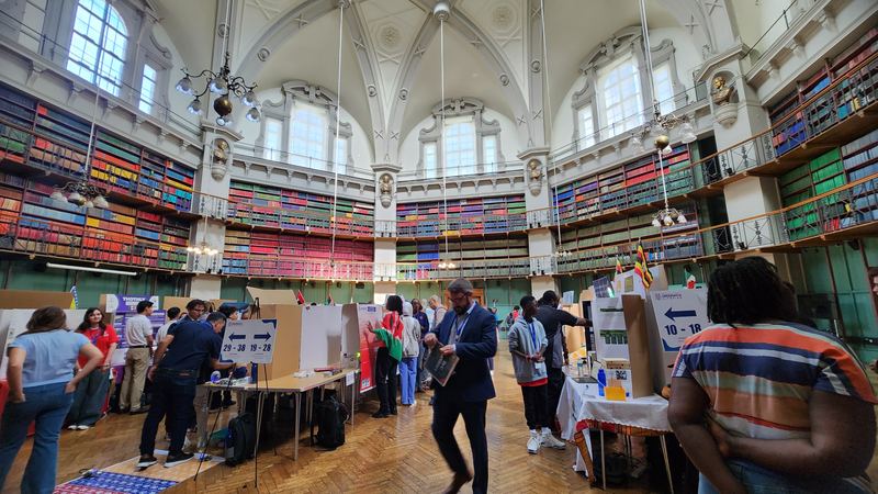 Project booths inside a historic octagonal library lined with colourful books